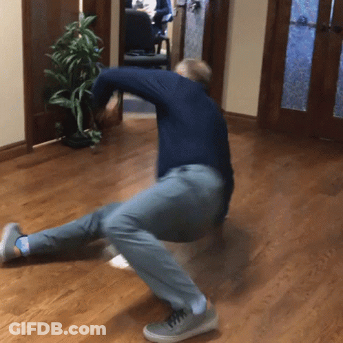 A Man In A Blue Shirt And Grey Pants Is Kneeling Down On The Floor GIF