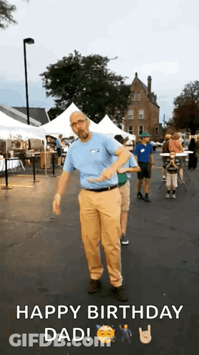 A Man In A Blue Shirt And Tan Pants Is Dancing In A Parking Lot While Someone Says Happy Birthday Dad . GIF