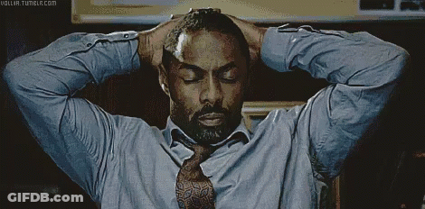 A Man In A Blue Shirt And Tie Holds His Hands To His Head GIF