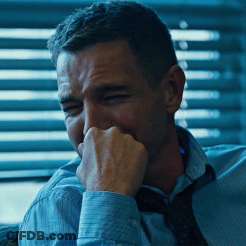 A Man In A Blue Shirt And Tie Is Covering His Mouth GIF