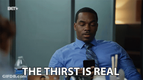 A Man In A Blue Shirt And Tie Is Holding A Cell Phone And Says " The Thirst Is Real " GIF