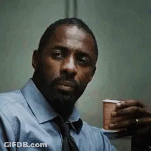 A Man In A Blue Shirt And Tie Is Holding A Cup Of Coffee In His Hand . GIF