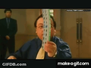 A Man In A Blue Shirt And Tie Is Holding A Stack Of Playing Cards GIF