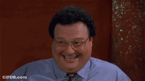A Man In A Blue Shirt And Tie Is Laughing . GIF