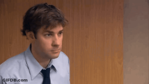 A Man In A Blue Shirt And Tie Is Looking At Something . GIF