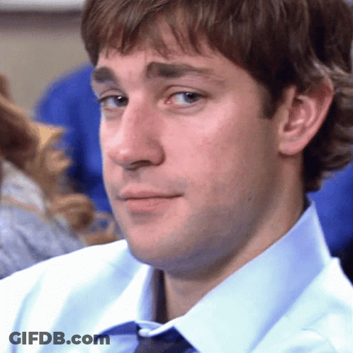 A Man In A Blue Shirt And Tie Is Looking At The Camera GIF