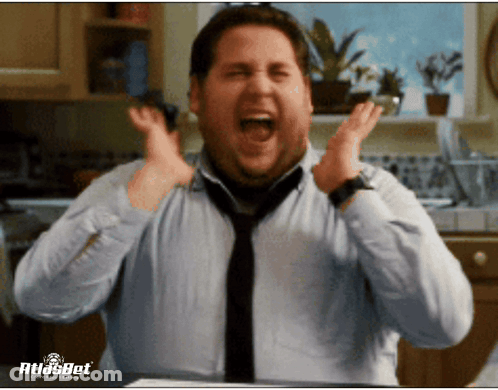A Man In A Blue Shirt And Tie Is Screaming In A Kitchen With Atlasbet Written On The Bottom GIF