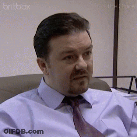 A Man In A Blue Shirt And Tie Is Sitting In A Chair . GIF