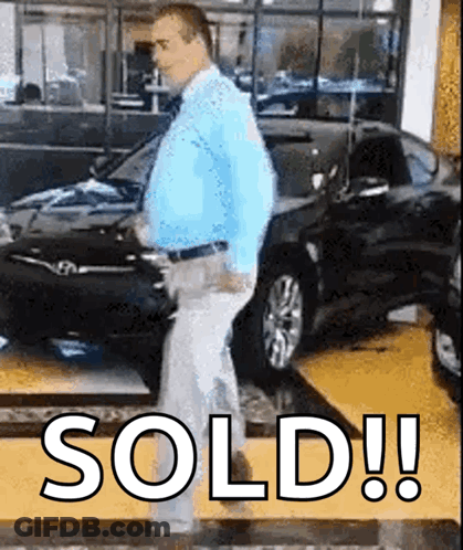 A Man In A Blue Shirt And Tie Is Standing In Front Of A Car That Has The Word Sold Written On The Floor GIF