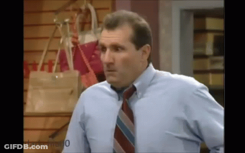 Man In Blue Shirt And Tie In Front Of Handbag Wall GIF