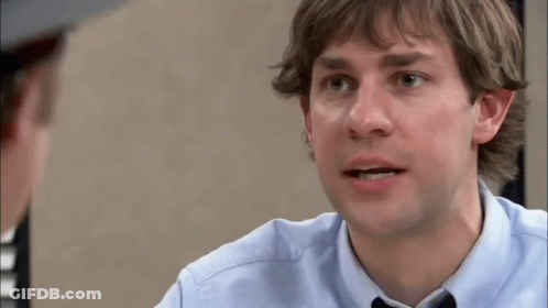 A Man In A Blue Shirt And Tie Is Talking To Another Man In A Hat . GIF