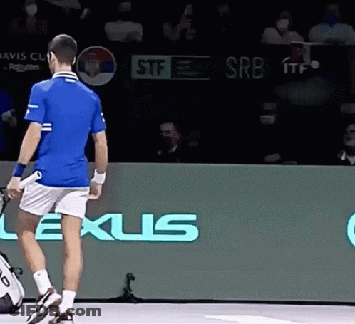 A Man In A Blue Shirt And White Shorts Is Holding A Tennis Racquet In Front Of A Lexus Sign . GIF