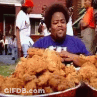 A Man In A Blue Shirt Eating Fried Chicken GIF