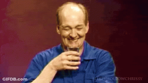A Man In A Blue Shirt Holds A Glass Of Wine GIF