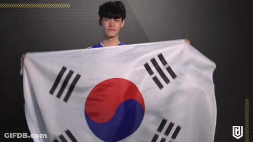 A Man In A Blue Shirt Holds A Korean Flag In His Hands GIF