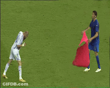 A Man In A Blue Shirt Holds A Red Cloth Over A Man In A White Shirt GIF