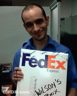 A Man In A Blue Shirt Holds Up A Fedex Express Box GIF