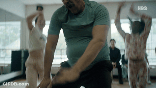 A Man In A Blue Shirt Is Dancing In A Room With A Hbo Logo On The Bottom GIF