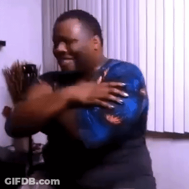 A Man In A Blue Shirt Is Dancing In Front Of A Window In A Room . GIF