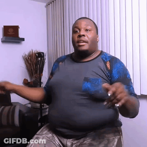 A Man In A Blue Shirt Is Dancing In Front Of A Window With Blinds GIF