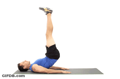 A Man In A Blue Shirt Is Doing A Leg Lift Exercise On A Yoga Mat GIF