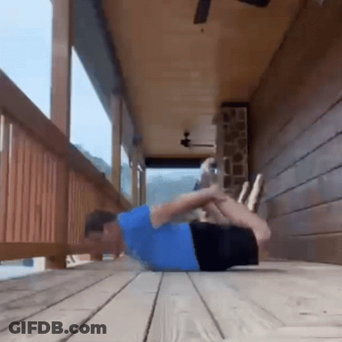 A Man In A Blue Shirt Is Doing Push Ups On A Porch . GIF