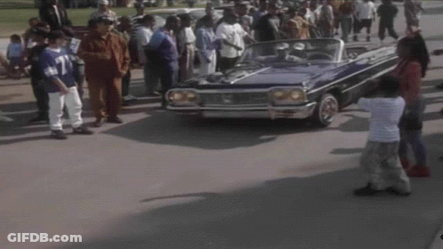 A Man In A Blue Shirt Is Driving A Blue Car GIF