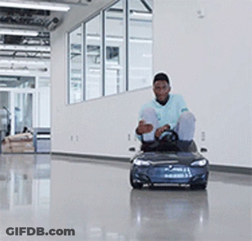 A Man In A Blue Shirt Is Driving A Blue Toy Car GIF