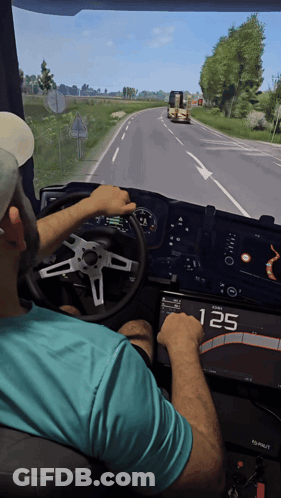 A Man In A Blue Shirt Is Driving A Truck With The Number 125 Displayed On The Dashboard GIF