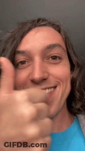 A Man In A Blue Shirt Is Giving A Thumbs Up GIF