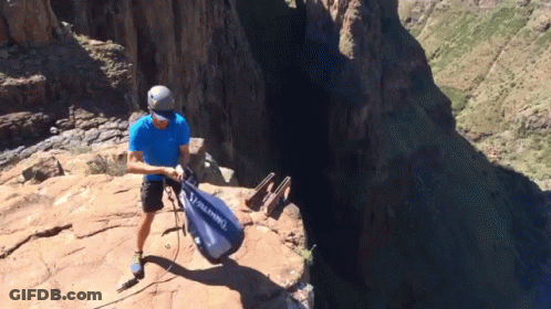 A Man In A Blue Shirt Is Holding A Bag That Says Alpina GIF
