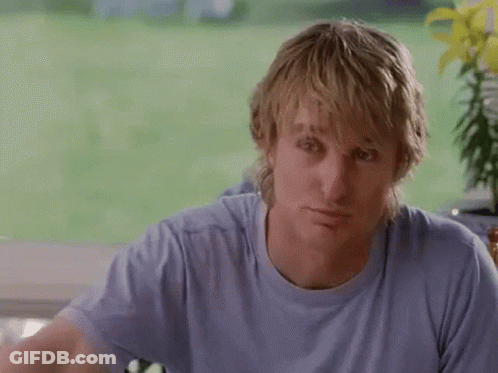 A Man In A Blue Shirt Is Holding A Bottle Of Coke Over His Head . GIF
