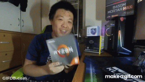 A Man In A Blue Shirt Is Holding A Box Of Ryzen GIF