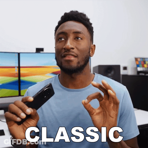 A Man In A Blue Shirt Is Holding A Cell Phone And The Word Classic Is On The Screen GIF