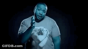 A Man In A Blue Shirt Is Holding A Pair Of Scissors In His Hands . GIF