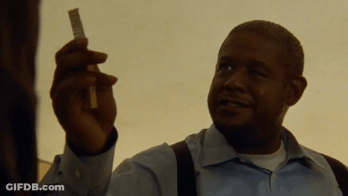 A Man In A Blue Shirt Is Holding A Piece Of Paper In His Hand GIF