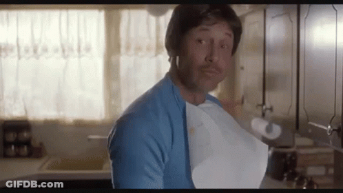 A Man In A Blue Shirt Is Holding A Piece Of Paper In His Mouth . GIF