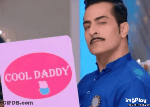 A Man In A Blue Shirt Is Holding A Pink Card That Says Cool Daddy GIF