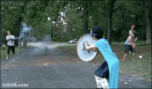 A Man In A Blue Shirt Is Holding A Shield While Playing Frisbee GIF