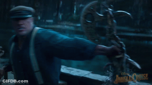 A Man In A Blue Shirt Is Holding A Statue With Jungle Cruise Written On The Bottom Right GIF
