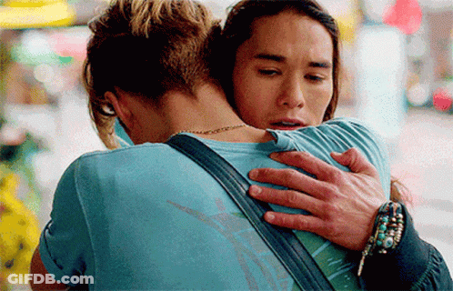 A Man In A Blue Shirt Is Hugging A Woman In A Blue Shirt GIF