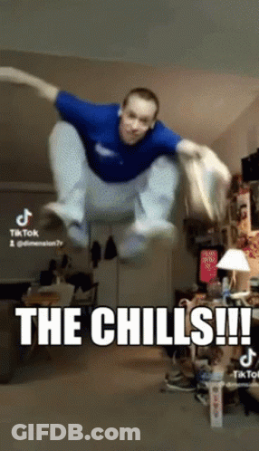 A Man In A Blue Shirt Is Jumping In The Air With The Caption The Chills GIF