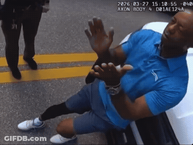 A Man In A Blue Shirt Is Kneeling Down With His Hands Up GIF