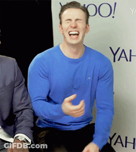 A Man In A Blue Shirt Is Laughing In Front Of A Yahoo Banner GIF
