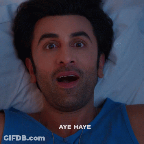 A Man In A Blue Shirt Is Laying On A Bed With The Words Aye Haye Written Below Him GIF