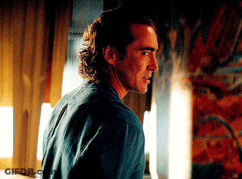 A Man In A Blue Shirt Is Looking At Something GIF