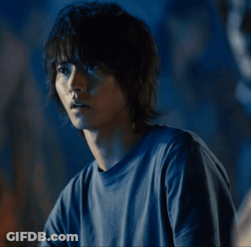 A Man In A Blue Shirt Is Looking To The Side GIF
