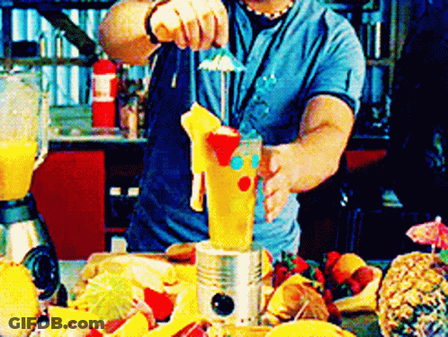 A Man In A Blue Shirt Is Making A Drink With A Blender GIF