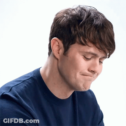 A Man In A Blue Shirt Is Making A Face GIF