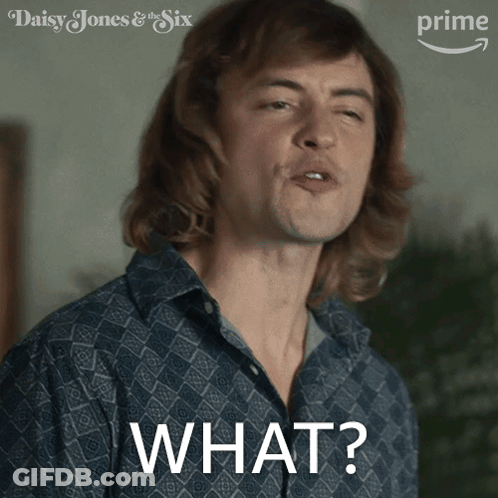 A Man In A Blue Shirt Is Making A Funny Face And The Word What Is On The Front Of His Shirt GIF